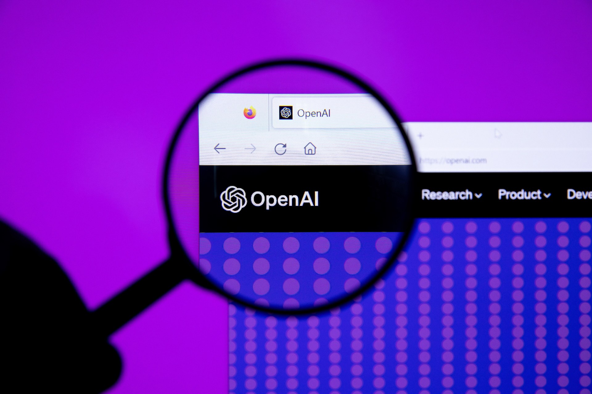 Az OpenAI logója nagyító alatt egy weboldalon